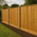 Wooden garden fence with lush greenery, showcasing popular garden fencing design and materials